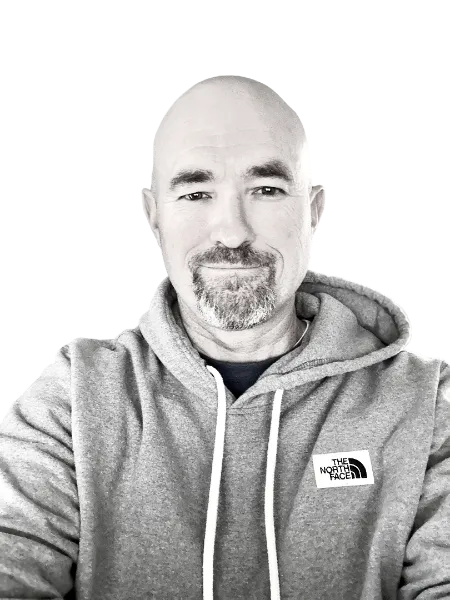 Brandon Beecroft, smiling, in a grey hoodie.